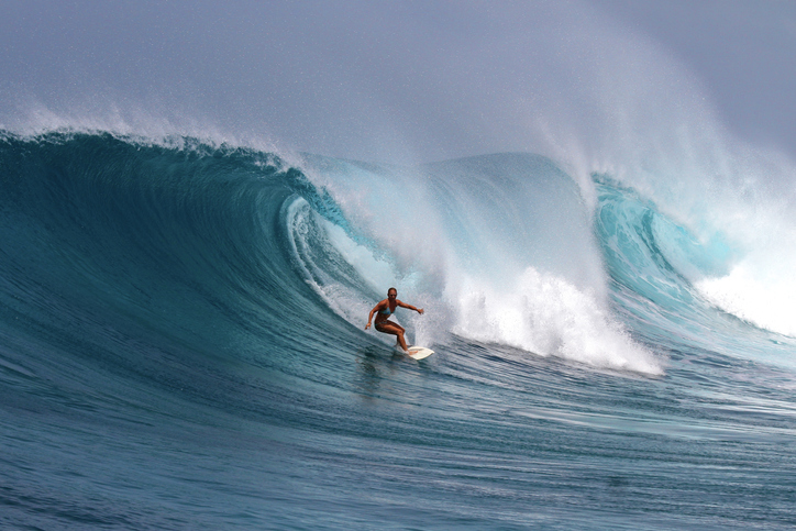 A surfer moving across an ocean wave